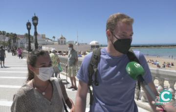 Dos turistas frente en la  Playa de La Caleta 
