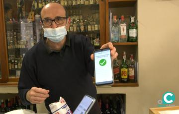 Un trabajador de uno de los bares de la capital muestra el certificado Covid de uno de sus clientes
