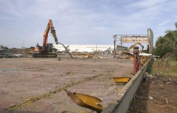 Una máquina pesada realiza los últimos trabajos de desmantelamiento de la antigua planta de automoción
