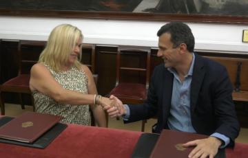 El alcalde de Cádiz y la presidenta de la Asociación de Comerciantes de Extramuros se estrechan la mano tras la firma del convenio