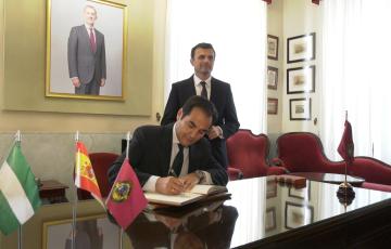 El consejero de Justicia firmando en el Libro de Honor en el despacho de alcaldía, junto a la alcalde.