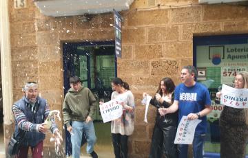 Los propietarios de la administración número 3 de la calle José del Toro descorchando una botella de champán.