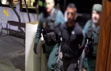 Un detenido custodiado por agentes de la Guardia Civil en Villamartín, acusado de incendiar el vehículo de un agente