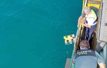 Efectivos del dispositivo de búsqueda sumergiendo un robot subacuático