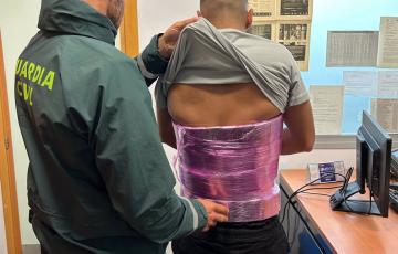 Agente de la Guardia Civil con la persona detenida. 