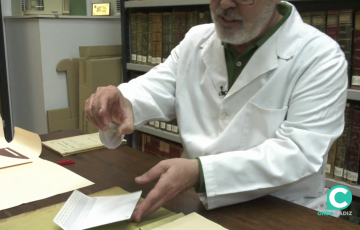 El técnico del archivo histórico muestra la lente hallada entre los papeles del Gran Teatro Falla