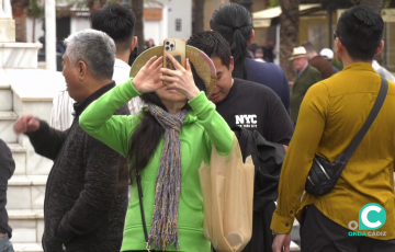 Una turista toma una foto en la plaza San Juan de Dios