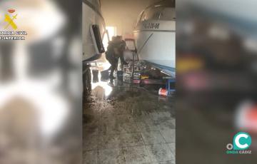 Los agentes rescatan a la víctima del interior de la nave en llamas. 