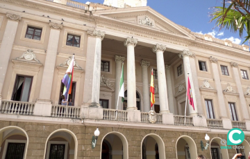 La fachada del Ayuntamiento con las respectivas enseñas oficiales ondeando junto con la bandera multicolor 