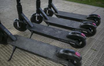 Patinetes eléctricos aparcados en la acera.