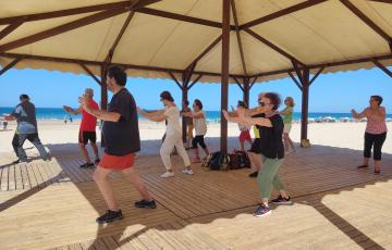 Taller de taichi en la playa para personas mayores en el Módulo Malibú de la Playa de la Victoria.