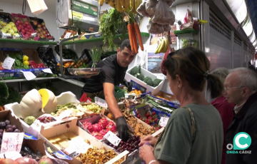 Un detallista con sus clientes este viernes en el Mercado Virgen del Rosario