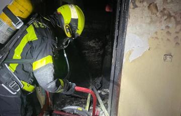 Un efectivo de bomberos sofocando el incendio en la vivienda. 