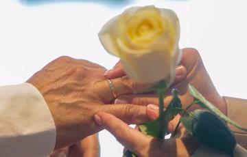 Una pareja se coloca las alianzas en la celebración de su boda. 