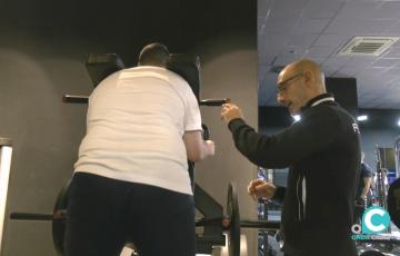 Un monitor de gimnasio imparte instrucciones a un usuario 