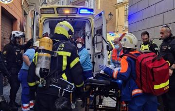Efectivos de bomberos, policías y personal sanitario evacuando a uno de los afectados en el siniestro