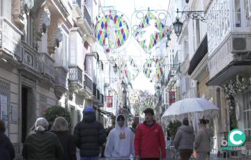 Viandantes pasean bajo la instalación por el centro de la capital gaditana