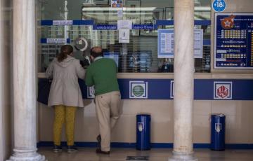 Dos personas compran lotería en una Administración de Cádiz. 
