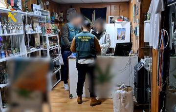 Un agente de la Guardia Civil en uno de los locales de venta de marihuana registrados en una operación en Cádiz