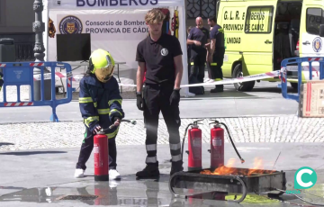 Un escolar participa en una demostración practica para sofocar un fuego