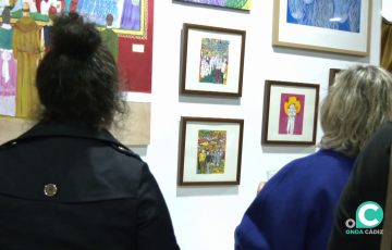 Dos mujeres observan alguna de las creaciones expuestas en la cafetería del hostal Rosa de los Vientos