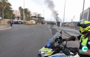 Un agente de Policía Local observan piquetes en la rotonda de la carretera industrial.