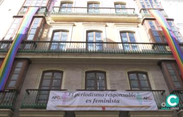 Dos banderas LGTBIQ+ lucen en la fachada de la APC.