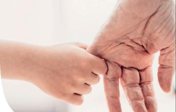Un abuelo coge de la mano a su nieto en una imagen de archivo.