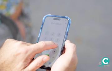 Una persona agenda en su dispositivo móvil el número de teléfono andaluz de atención a las mujeres. 