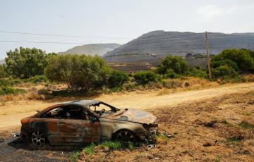 Vegetación y coche calcinado por las llamas en el lugar del siniestro