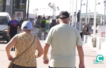 Viandantes paseando por el paseo marítimo de Cádiz. 