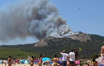 Unos bañistas observan la magnitud del siniestro en Tarifa el pasado lunes