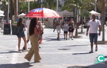 Una mujer se protege del sol en la plaza de San Juan de Dios