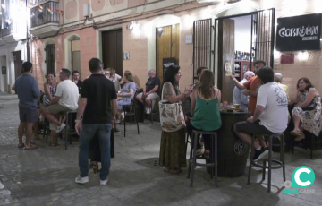 Clientes en las mesas del exterior en un establecimiento en el centro de la ciudad