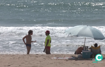 Un bañista habla con personal de salvamento en la capital gaditana