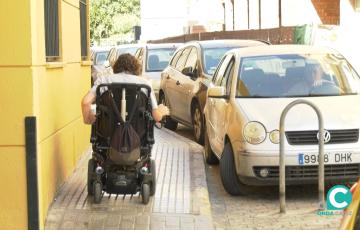 Una persona con movilidad reducida circulando por una acera.