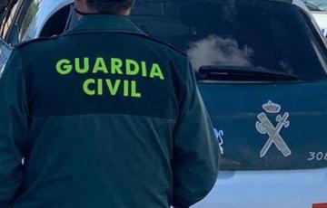 Agente junto a un vehículo oficial en una iamgen de archivo