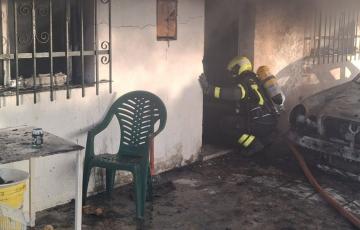 Un bombero actuando en la entrada del inmueble donde se produjo el siniestro