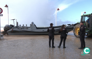 Agentes junto a la embarcación en su retirada en el paseo marítimo de la capital gaditana