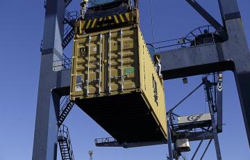 Una grúa carga un contenedor en un buque en el Puerto de Cádiz.