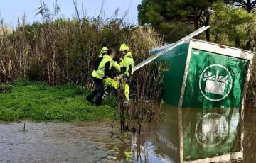 Efectivos de bomberos observan el estado del vehículo siniestrado
