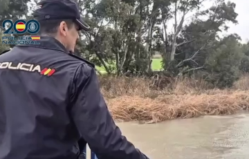 Un policía nacional observa la zona inundada por el rio Guadalete en el termino de Jerez