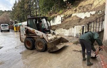Operarios de Alcalá del Valle trabajan en una calle sobre los efectos del temporal de lluvia.