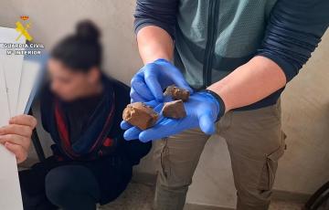 Un agente muestra un trozo de hachís incautado en un punto de venta de droga desarticulado en Barbate.