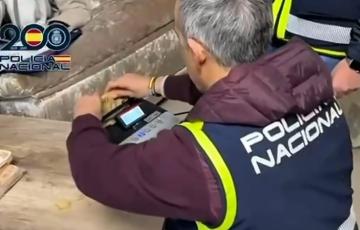 Un agente cuenta dinero intervenido a una organización dedicada al tráfico de armas para el narcotráfico.