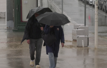 Dos viandantes con paraguas por el Paseo Marítimo de al capital gaditana en una imagen de archivo