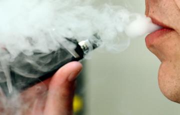  Un hombre exhalando mientras usa un vapeador