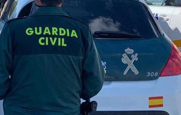Imagen de archivo de un agente de la Guardia Civil junto a un vehículo oficial