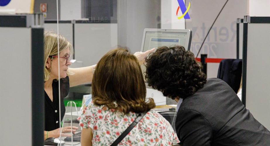 Usuarios atendidos en uno de los mostradores de una oficina de la agencia tributaria