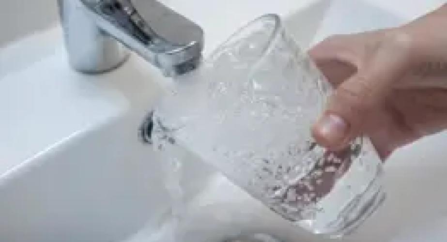 Una persona se sirve un vaso de agua del grifo